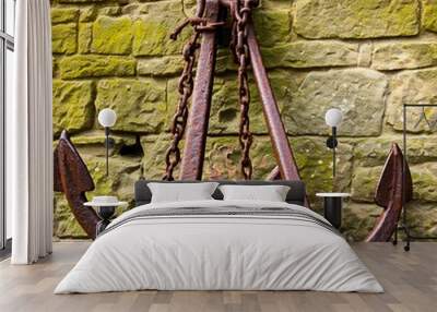 Two rustic anchors with chains leaning on the old wall Wall mural