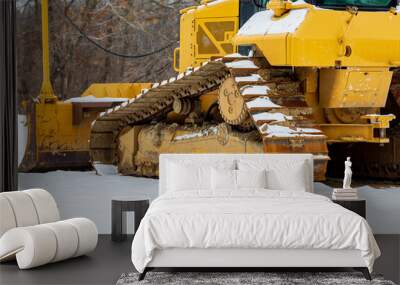 Bulldozer at construction site after winter snow storm. Concept of construction industry, work delay and stoppage. Wall mural