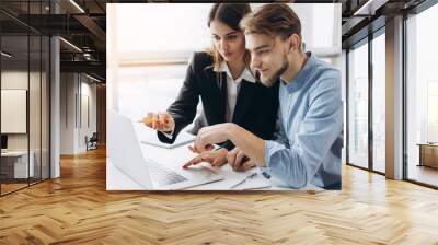 Image of two young business workers working together on project at office Wall mural