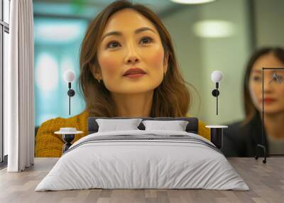 A young Asian woman listens intently during a meeting. Wall mural