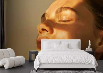 close-up of serene woman's face basking in warm sunlight with shadows Wall mural