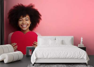 Happy Woman Holding a Red Paper Valentines Day Heart on a Pink Colored Background with Space for Copy Wall mural