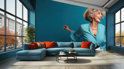 Older Fashionable Lady Dancing Against a Blue Background with Space for Copy (Generative AI) Wall mural