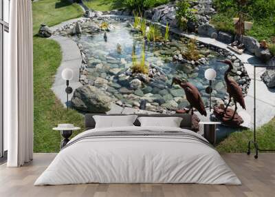 Zen ornamental pound, surrounded by metal bird sculptures. Embellished with rocks and the bottom lined with pretty stones. Water iris and aquatic plants. Wall mural