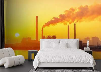 Industrial scenery at sunset with smokestacks releasing emissions over a river. Wall mural