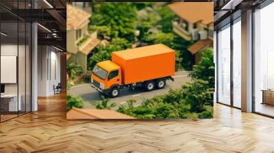 Orange delivery truck driving through a residential area surrounded by houses and greenery. Wall mural