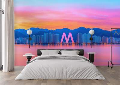 Vibrant sunset over city skyline with mountains, reflecting on calm water, creating a serene urban landscape. Wall mural