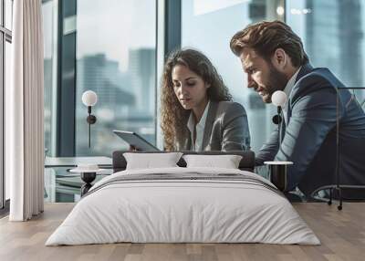 Two business people, a business man and a business woman, engage in a discussion as they read a financial report together. Wall mural