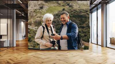 Happy senior couple having a video call while hiking Wall mural