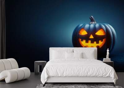 A halloween lit Jack O Lantern in a spotlight glow on a wide dark blue background Wall mural