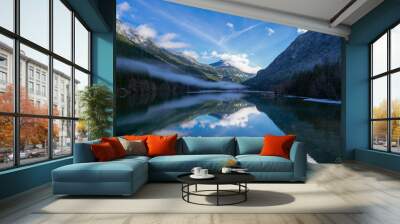 Beautiful view of a lake with the reflection of surrounding mountains Wall mural