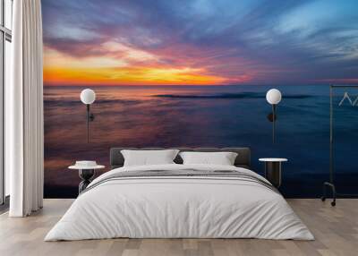 Beautiful view of the sea with waves at orange sunset Wall mural