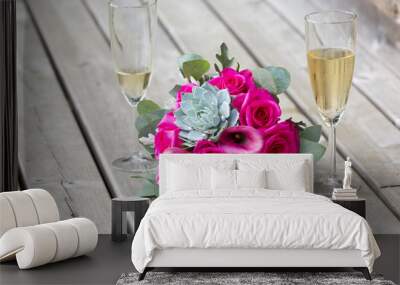 Beautiful flower bouquet next to a champagne glasses. Wall mural