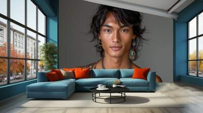 A young man of Central Asian descent wearing a multicolored necklace and earrings Wall mural