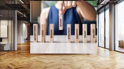 Businesswoman hand placing or pulling wooden Dominoes with BRAND text. and Marketing, Advertising, Logo, Design, Strategy, Identity, Trust and Values. Product development concept Wall mural