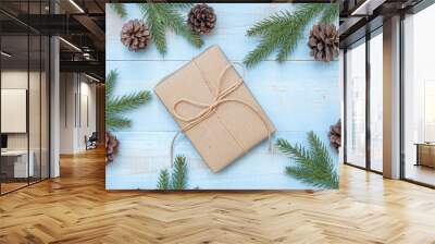 Christmas decoration, gift box and pine tree branches on wooden background, preparation for holiday concept, Happy New Year and Xmas Holidays. Top view and Copy Space for text Wall mural