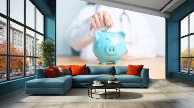 Doctor holding piggy bank and putting coin. and Healthcare cost, Money Saving, Health Insurance, Medical, Donation and Financial concepts Wall mural