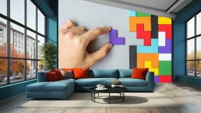 hand connecting geometric shape block with colorful wood puzzle pieces. logical thinking, business logic, Conundrum, decision, solutions, rational, mission, success, goals and strategy concepts Wall mural