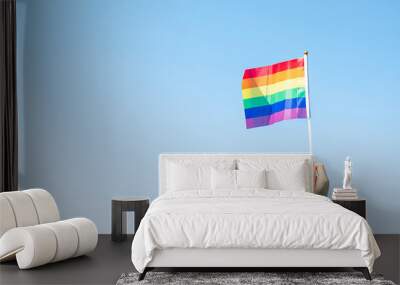 hands showing LGBTQ Rainbow flag on nature background. Support Lesbian, Gay, Bisexual, Transgender and Queer community and Pride month concept Wall mural