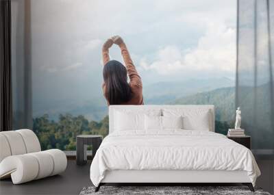 Happy woman relaxing and looking mountain view at countryside home or homestay in the morning. Vacation, blogger, SoloTravel, journey, trip and relaxing concept Wall mural