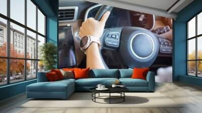 woman driver driving a car on the road, hand controlling steering wheel in electric modern automobile. Journey, trip and Transportation concepts Wall mural