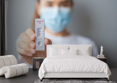 woman holding Rapid Antigen Test kit with Positive result during swab COVID-19 testing. Coronavirus Self nasal or Home test, Lockdown and Home Isolation concept Wall mural