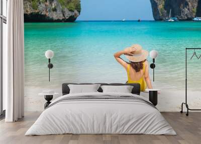 Woman tourist in yellow swimsuit and hat, happy traveller sunbathing at Maya Bay beach on Phi Phi island, Krabi, Thailand. landmark, destination Southeast Asia Travel, vacation and holiday concept Wall mural