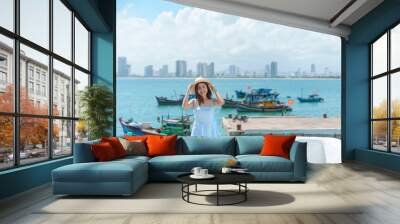 Woman traveler visiting at Son Tra marina. Tourist with blue dress and hat traveling in Da Nang city. Vietnam and Southeast Asia travel concept Wall mural