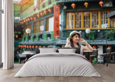 woman traveler visiting in Taiwan, Tourist with hat sightseeing in Jiufen Old Street village with Tea House background. landmark and popular attractions near Taipei city . Travel and Vacation concept Wall mural