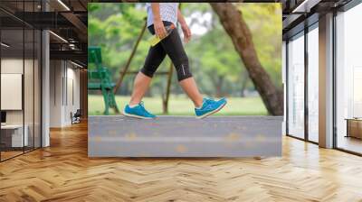 young fitness woman legs walking in the park outdoor, female runner running on the road outside, asian athlete jogging and exercise on footpath in sunlight morning. Sport,healthy and wellness concepts Wall mural