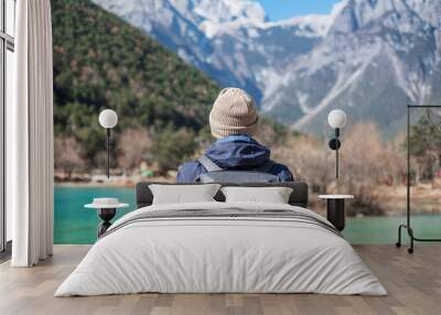 Young man traveler traveling at Blue Moon Valley, landmark and popular spot inside the Jade Dragon Snow Mountain Scenic Area, near Lijiang Old Town. Lijiang, Yunnan, China. Solo travel concept Wall mural