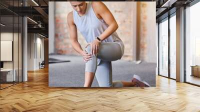 Woman with a knee injury, pain or accident at the gym while doing workout or sport training. Fitness, athlete and female with swollen, sore or sprain muscle in her leg after exercise in sports center Wall mural