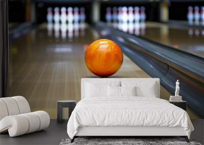 A bright orange bowling ball rolls down the lane at a busy bowling alley, aiming for the pins during a lively evening of bowling fun Wall mural