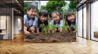 A group of curious and carefree young asian children joyfully sits atop a mound of earth, embracing their natural surroundings. Wall mural