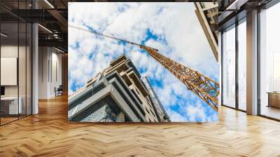 A large construction crane between two tall residential buildings. Wall mural