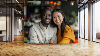 A positive multiracial couple sitting at a table in a café. Wall mural