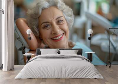 An elderly woman smiles during a dental examination in the chair at the dentist clinic. Wall mural