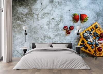 Close-up of waffles with tasty fruits cranberries, cherries and strawberries viewed from above, isolated on abstract background with copy space for text. Wall mural