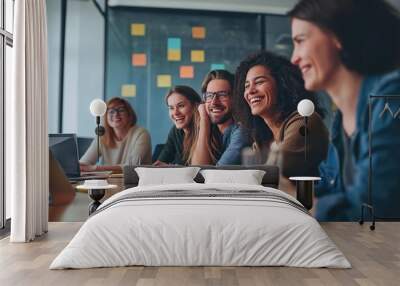 Employees smile during a strategic meeting of a startup of young workers. Wall mural