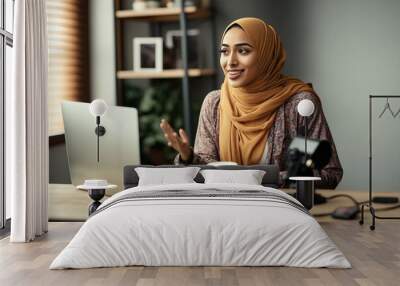 Muslim woman working on her computer in her office. Ai generated. Wall mural