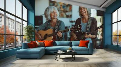 Two elderly women joyfully playing acoustic guitars and smiling in a cozy indoor setting, enjoying a musical afternoon together Wall mural