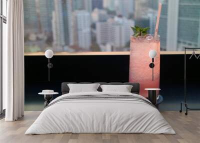 Pastel pink cocktail drink on the rooftop terrace with blurry skyscrapers view in the backdrop Wall mural