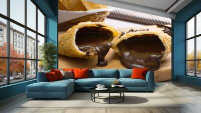 One open tradional Brazilian fried pastry called pastel stuffed with chocolate Brazilian dessert brigadeiro in a cutting board with half light Wall mural