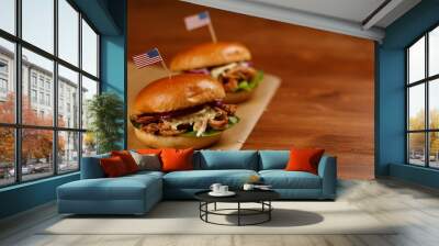 two pulled pork burgers on paper and wooden board with american flag Wall mural