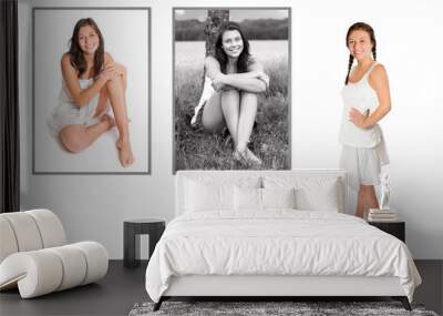 Beautiful young woman looking at two framed photos of herself, isolated in front of white background Wall mural