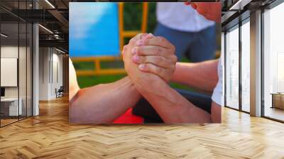 Men are fighting arm wrestling by clenching their hands tightly. Closeup photo Wall mural