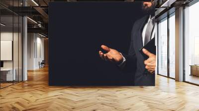 man in suit holding a bible in his arm speaking to another person on a black background Wall mural