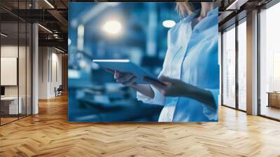 A woman is holding a tablet in a lab setting Wall mural