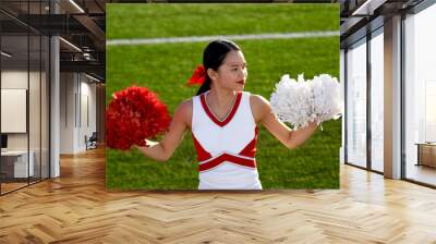 Attractive young cheerleader performing at a high school athletic event Wall mural