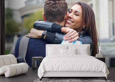 happy cheerful couple hugging and showing flying tickets. man making a surprise to a woman - giving tickets for a honeymoon Wall mural